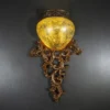 Antique Carved Wall Light with glowing amber shade and silver-brown finish