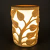 Sandstone garden light with vine-carved design glowing on a patio