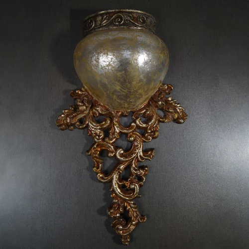 Antique Carved Wall Light with glowing amber shade and silver-brown finish