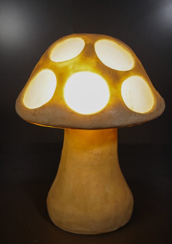 Glowing sandstone mushroom garden light with round carved cut-outs at night