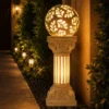 Sandstone garden pillar light with floral carved glowing sphere