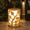 Sandstone garden light with vine-carved design glowing on a patio