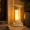 Sandstone fluted column garden light glowing warmly on a dark background