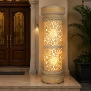 Faux sandstone double lantern pedestal with warm glowing light and intricate decorative pattern