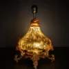 Ornate fiber glass hanging lamp with glowing decorative shade