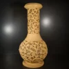 Sandstone flared vase garden light with intricate vine and floral carving and warm glowing illumination