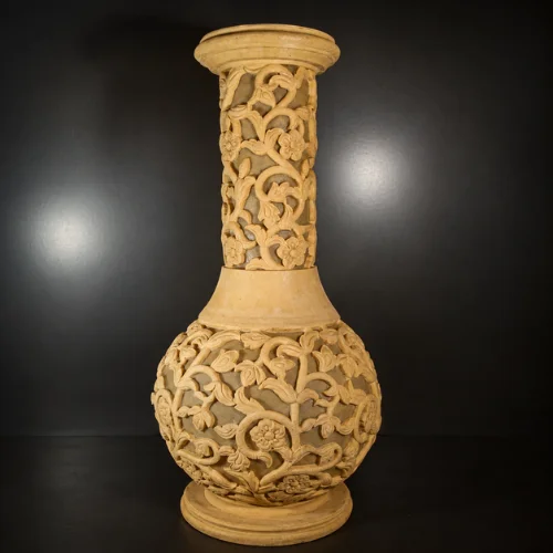 Sandstone flared vase garden light with intricate vine and floral carving and warm glowing illumination